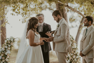 Groom placing the ring on his bride's finger at a small elopement in Michigan.