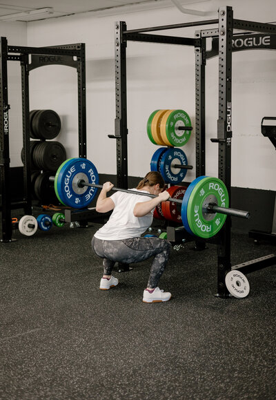 woman squatting with dumbbell
