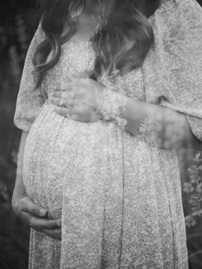 A close-up of a woman holding her pregnancy bump during a maternity photography session in Richmond by Katie Stansfield Photography.