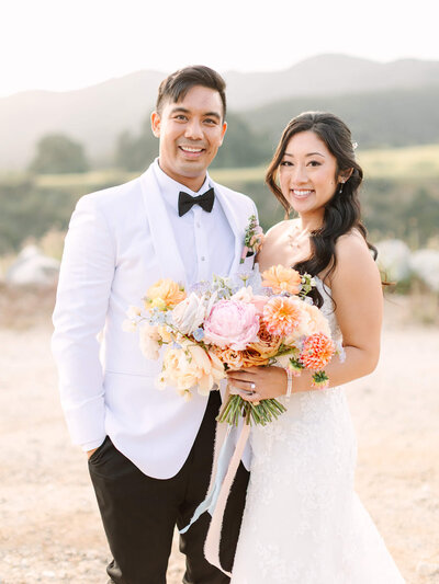 bride and groom holding hands adn colorful bouquet wedding photography at serendipity garden