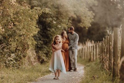 koppel-met dochter-bij-zonsondergang-zwangerschap-buiten.jpg

