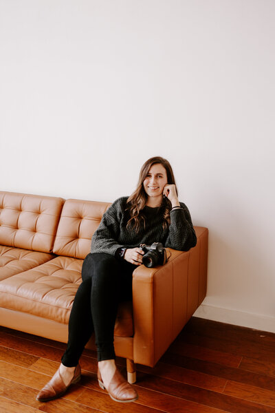 woman smiling at camera and sitting on couch