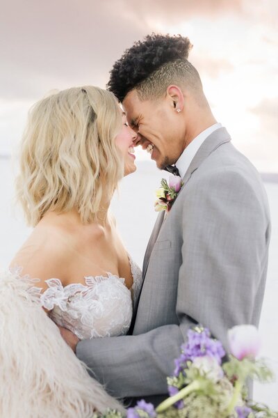 A bride and groom lean in close together at the Bonneville Salt Flats. 