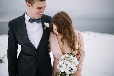 bride and groom laugh as they walk from their Fogo Island elopement ceremony