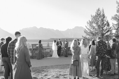 Bride and Groom with guests standing at ceremony standing in front of Snake River Overlook in Jackson  Hole Wyoming photographed by Jackson Hole LUXURY DESTINATION wedding photographer Magnolia Tree Photo Company