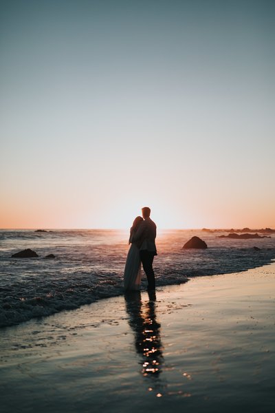 couple watches the sunset on a beach