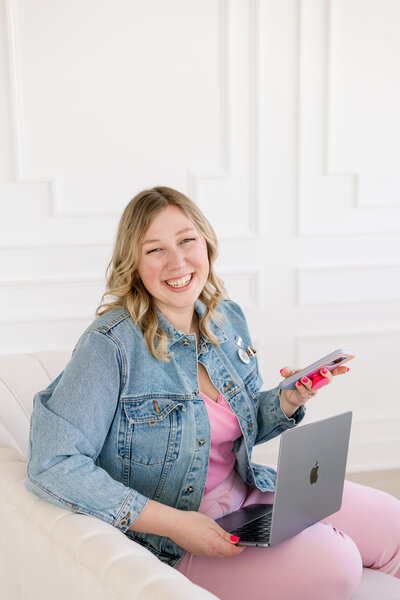 Kat Murphy in a pink Social Kat Media sweatshirt in front of a white wall