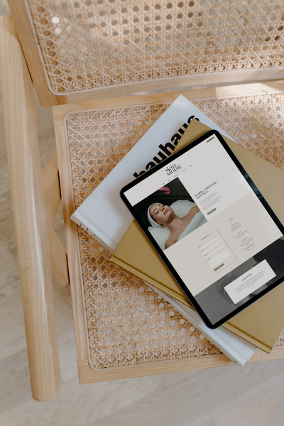 Aesthetic website design example by website designer Coja Creative placed on rattan chair