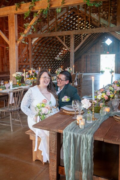 Bride and groom sitting together at a decorated wooden table