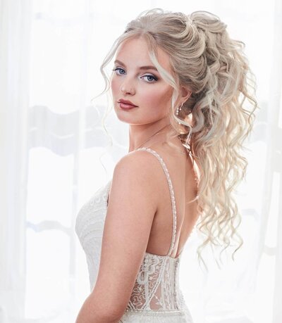 Bride wearing a voluminous high ponytail with soft texture — romantic, lifted bridal style by Klover Beauty in Maryland.