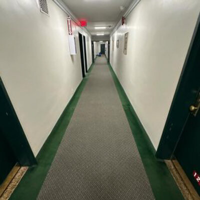 Long carpeted hallway in a building after cleaning