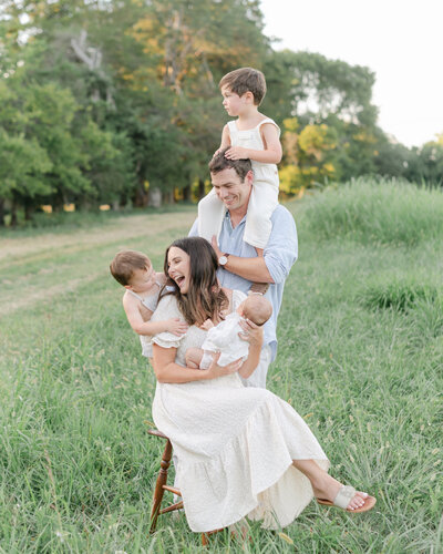 Richmond Family Photographer | A family in a green grass field in Richmond by light and airy film photographer, Jacqueline Aimee.