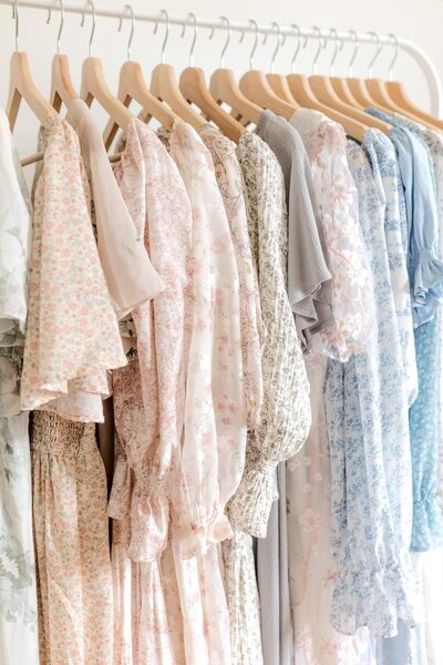 A selection of neutral colored dresses hanging on a rack