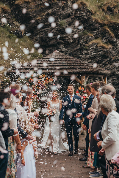 newlyweds in confetti tunnel