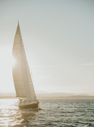 Couple embracing on a sailboat with the New York City skyline in the background during their romantic elopement session