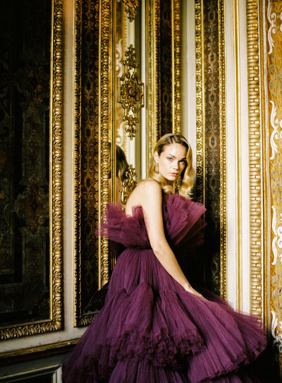 Fashion model in haute couture purple gown by Sara Mrad in gold trimmed room inside Villa Erba on Lake Como Italy photographed by Lake Como photographer Amy Mulder Photography