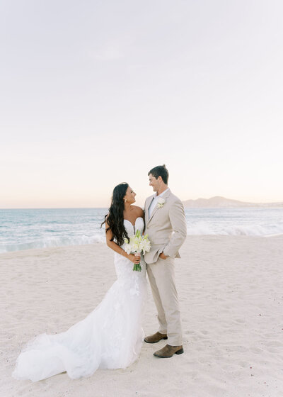 bride and groom kissing on the beach