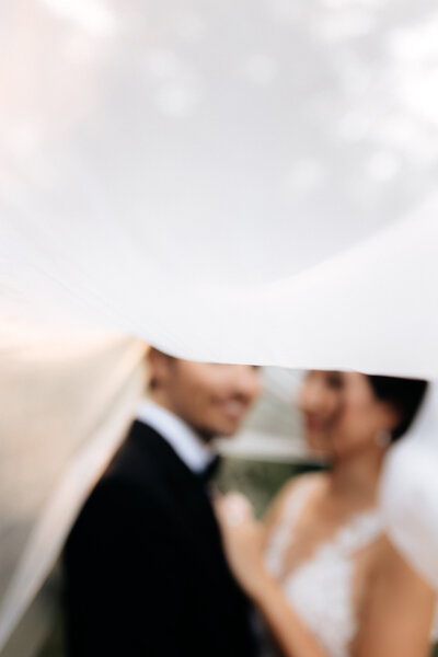 bride in lace wedding dress reaching to chandelier