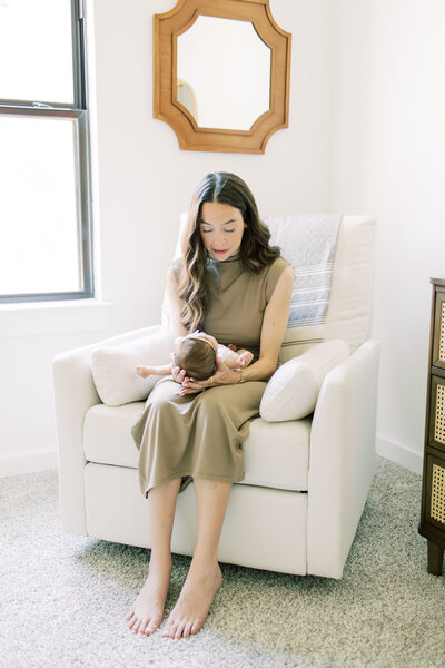 Mom-holding-newborn-in-rocking-chair-in-Austin