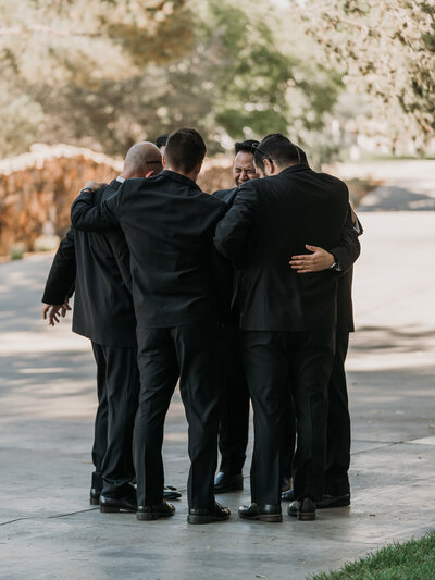 groom and groomsmen pray before wedding ceremony at blomgren ranch in santa clarita, ca