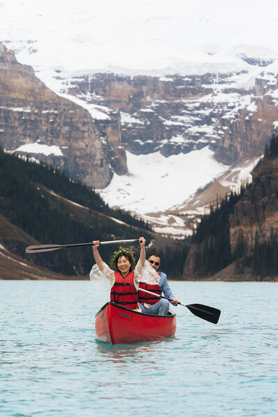 a bride and groom canoeing on lake louise in banff national park in canada
