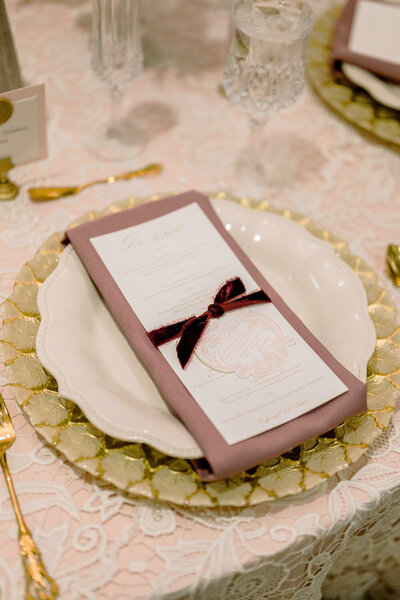wedding table with gold chargers, custom foil menus, and letterpress tag tied on with velvet ribbon