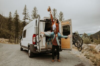 couple posing outside of a van