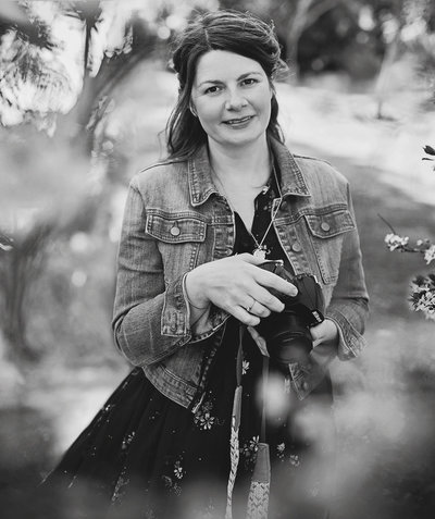 Black and white image of Jess Morgan holding camera.
