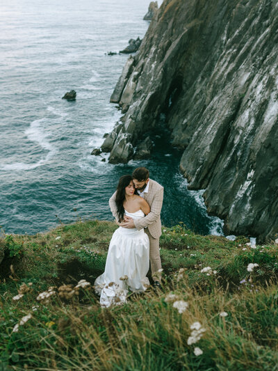 Cannon Beach elopement photo on a cliffside with black cliffs in the background. 