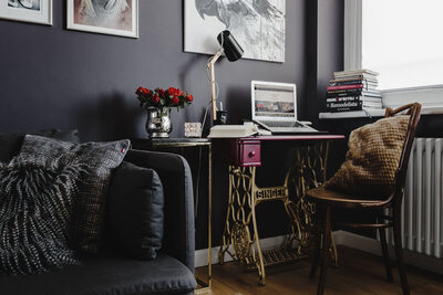 Home office setup with a magenta desktop set on a gold Singer sewing machine base.