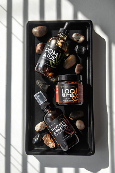 Queen of Kinks product photo of Loc Butta, Thymes a Wastin' Mist, and Pom-Aide moisturizer.