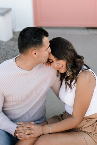 Couple sitting together wearing neutral engagement session outfit inspiration in Phoenix, Arizona.