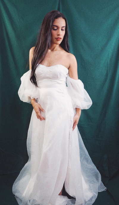 Elysia Anais, founder of Elyana Studio standing in a white ballgown against a dark green backdrop for Elyana Studio Showit Website branding