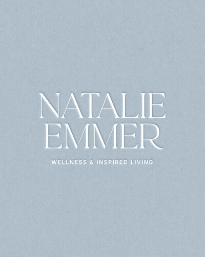 Elegant logo for Natalie Emmer, featuring refined serif typography and a soft blue background for a wellness and inspired living brand
