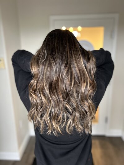 Brunette hair styled in loose waves at Maven + Grace Salon in McMinnville, Oregon, showcasing dimensional color and professional styling