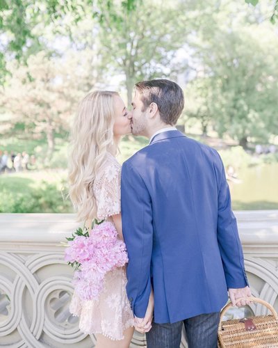 Couple kisses on Bow Bridge during Central Park engagement photos captured by Karina Mekel
