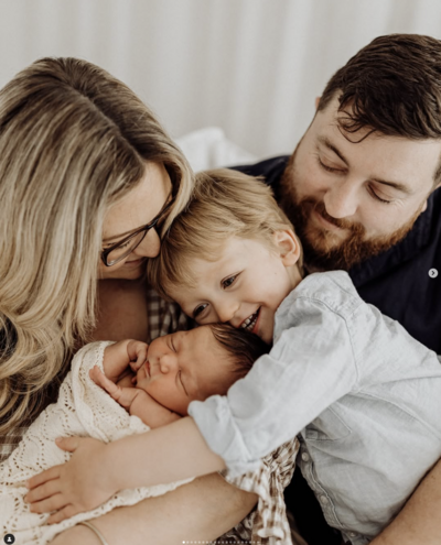 a family of four posing for the camera during a newborn photoshoot with lucy jane photography in christchurch