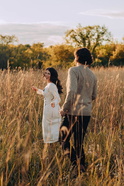 Bride and Groom walk alongside shoreline