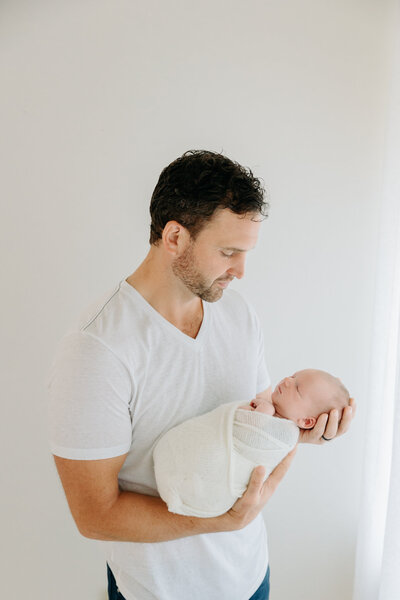dad holding baby at Wexford newborn photography studio