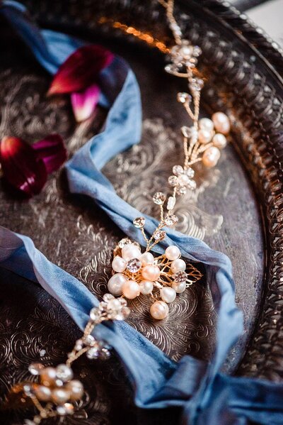 Pearl and diamond wedding headpiece beside a blue ribbon