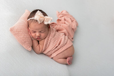 Baby girl in pink on mint backdrop with matching headband