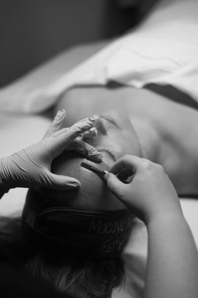 Close-up of Macayla Hopper performing dermaplaning service on client in her studio in Hartselle, Alabama