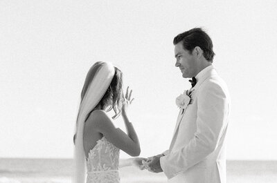 a groom looking tenderly at his bride while saying vows in hawaii