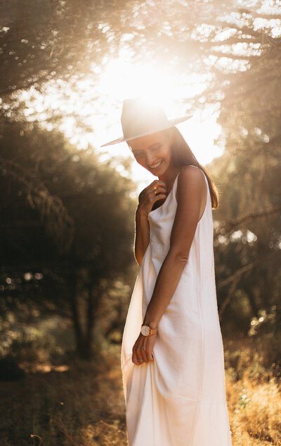 a portrait of a young woman wearing a white dress and a beige hat