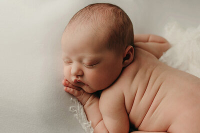 Close up of a sleeping baby with her hand under her cheek