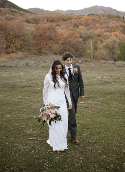 Married couple walking candidly while the bride holds her flowers.