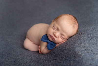 newborn boy with blue bowtie by Newborn Photography Bucks County PA