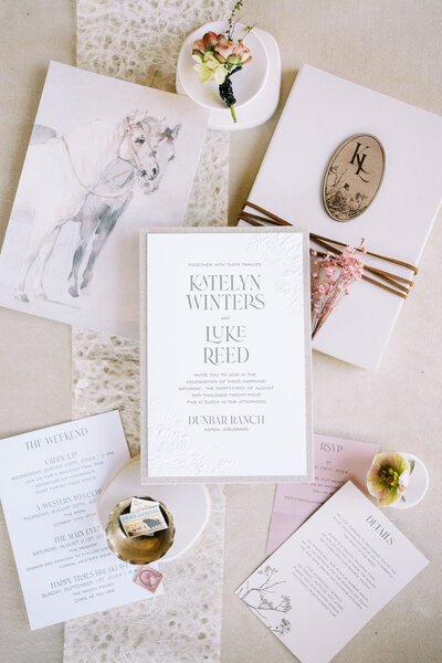 Flat lay of elegant wedding stationery decorated with flowers and stamps