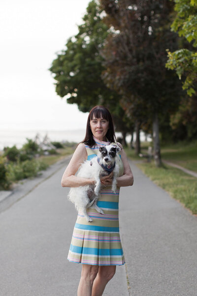 Woman holding her dog on a walk