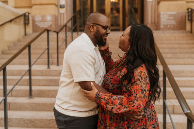 Couple embraces face to face in front of a city hall building in Phoenix